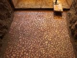 Floor mosaic made from red and while pebbles