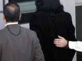Michael Jackson is brought in handcuffs to the 2003 trial