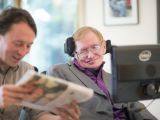 Professor Stephen Hawking and his Care Taker Pete read the newspaper