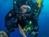 Diver Philip Short pictured inspecting the bronze spear recovered from the Antikythera Shipwreck
