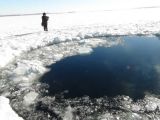 A whole in the ice possibly left by one piece of the meteor as it hit