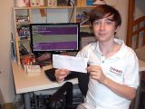 12-year-old security researcher Alexander Miller holding the $3,000 check from Mozilla