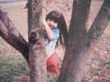 Photo shows Jennifer climbing a tree as a child