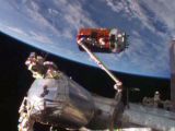 The cargo craft is captured by a robotic arm